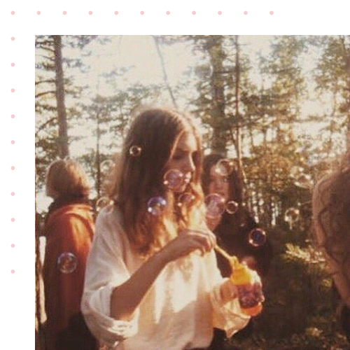 A woman standing in a group blowing bubbles
