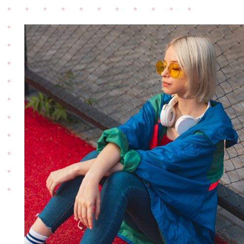 A women sitting down on the ground wearing bright colors