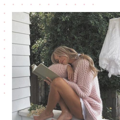 A girl reading a book on a outdoor porch