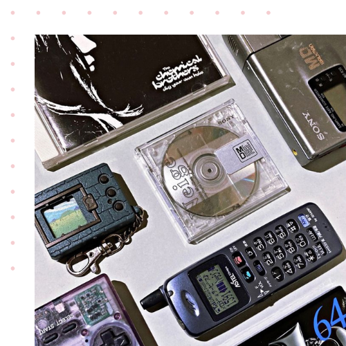 Early 2000s technology including a CD, and Digital camera laid on a table